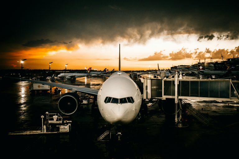 Hotels Near OR Tambo Airport: 5 Stays for Late Arrivals and Early Flights Aircraft parked at a gate at OR Tambo International Airport under a stormy sunset sky