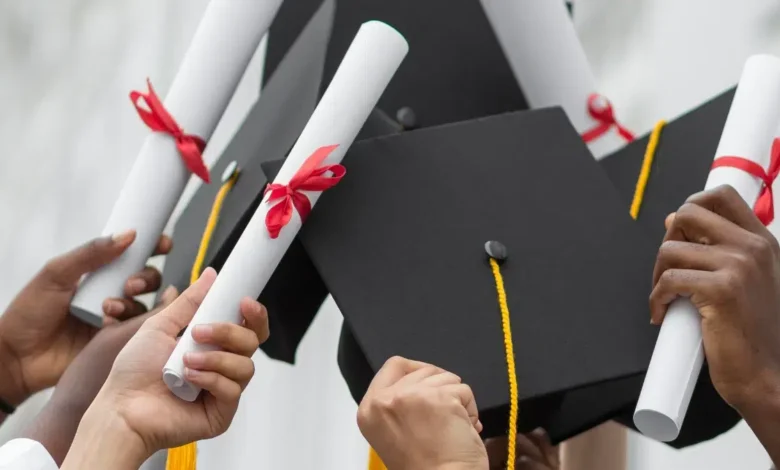 Graduation - Close up hands holding diplomas and caps