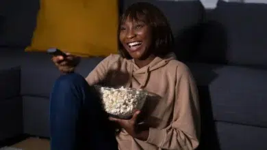 Lady holding popcorn with remote