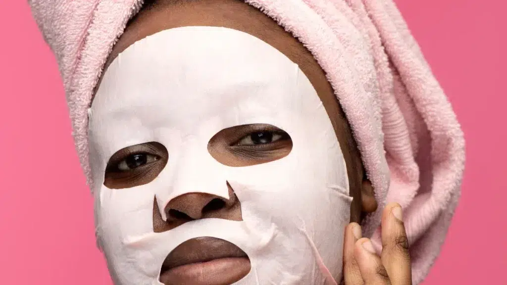 Side view of black woman with sheet face mask