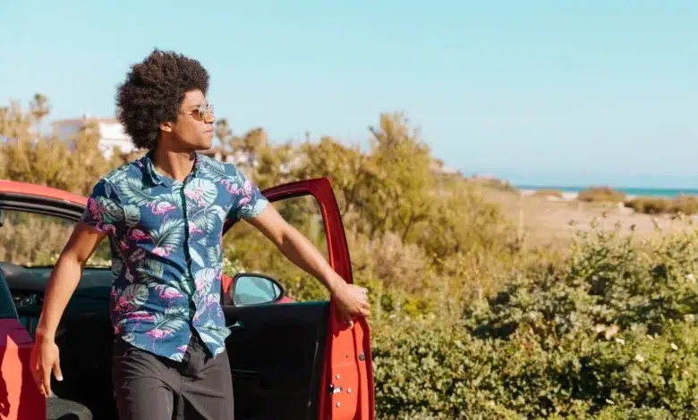 Young black man coming out of car on nature