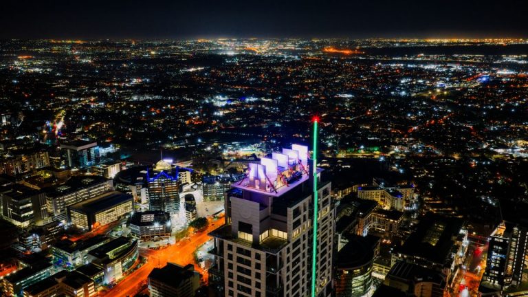Dumi Mkokstad – Renowned Gospel Singer-Songwriter Sandton skyline at night, Johannesburg