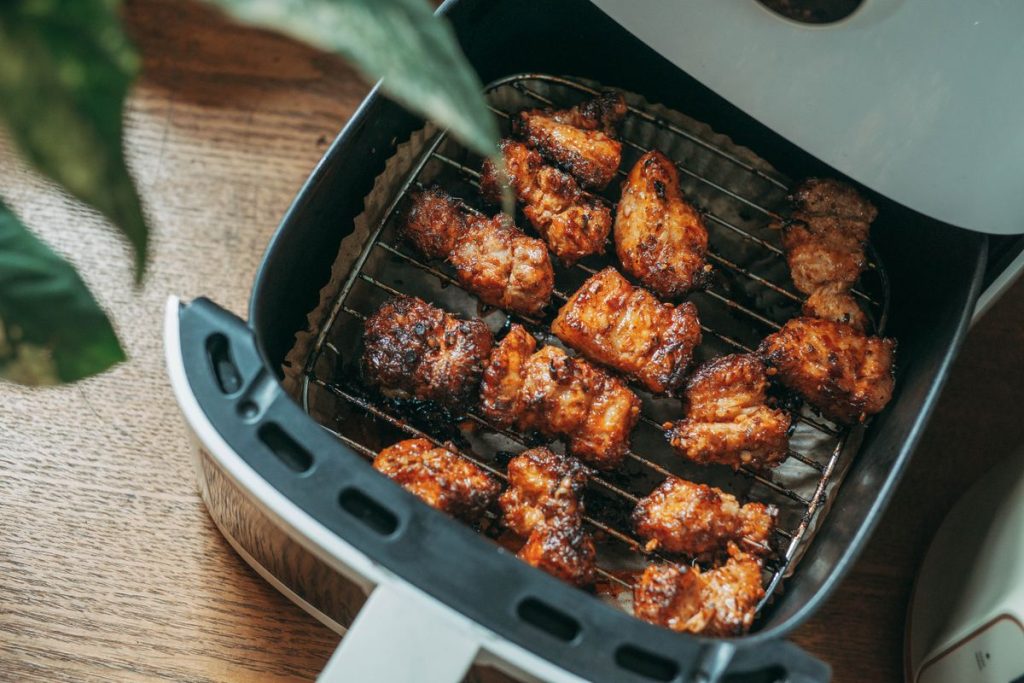 Chicken pieces cooking in an air fryer basket