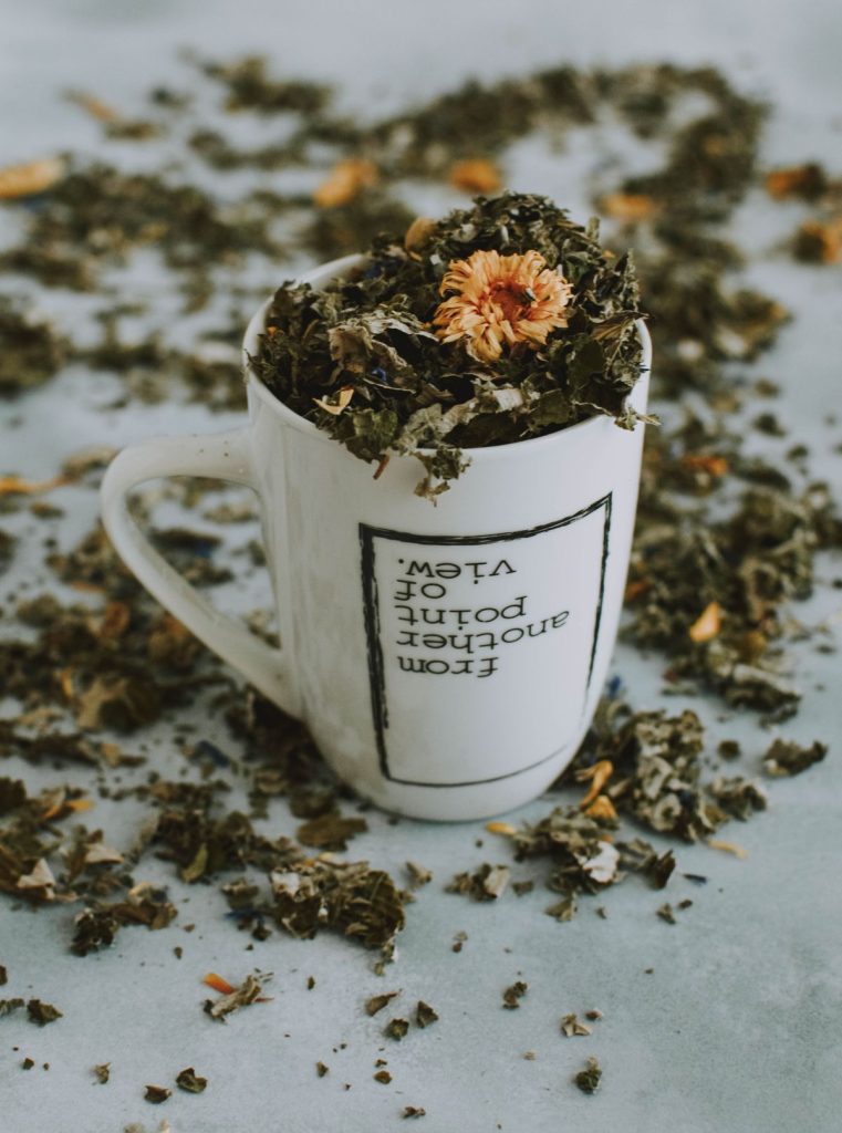 Mug filled with dried herbal tea leaves and flowers