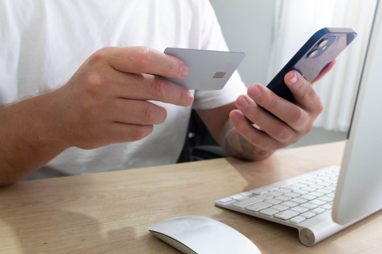 New Traffic Fine Scam Targets South African Drivers Through Fake PayCity Messages Hands holding a bank card and a smartphone