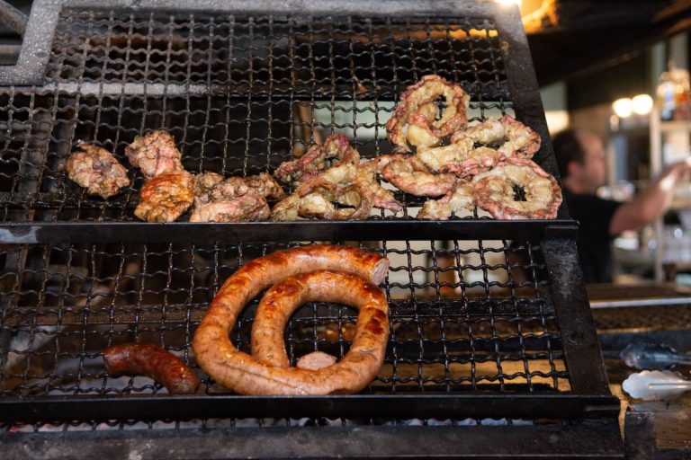 Top 10 Chisa Nyamas in Joburg: Best Braai Spots for Delicious Meat Sausages and meat cooking on a grill