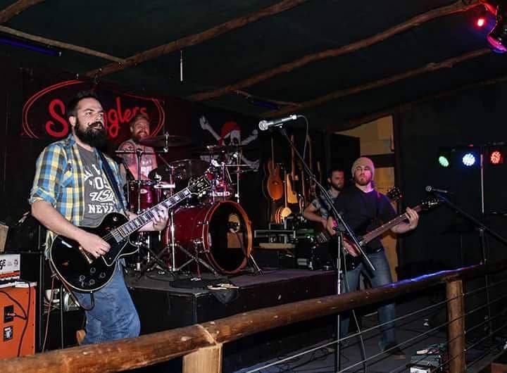 A live band performing on stage at Railways Cafe in Irene, Pretoria, with a cozy and vibrant atmosphere surrounded by music lovers.