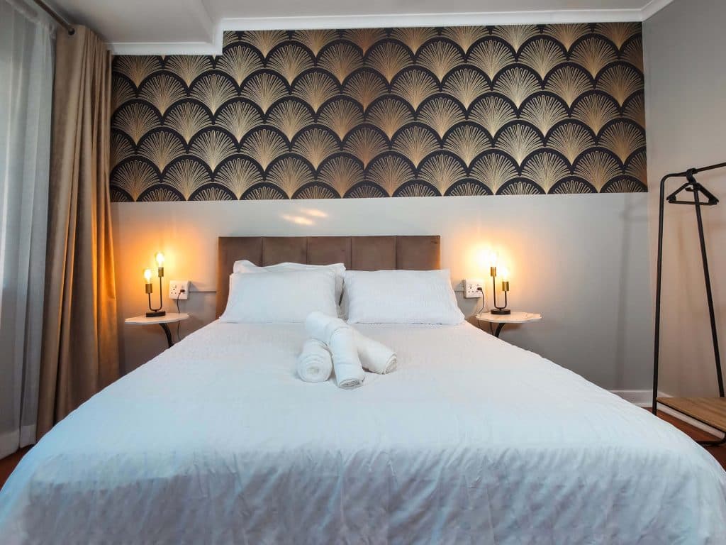 Guest bedroom with feature wallpaper at Tau Golden Mane Guest House